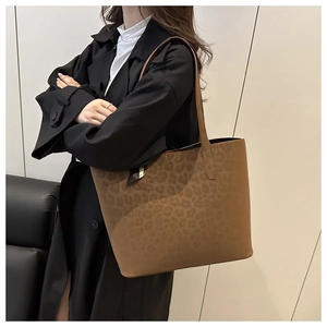 Close-up of leopard print tote bag in brown matte leather shown on a model