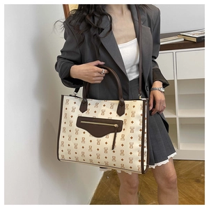 Detailed view of tote bag featuring bear patterns and functional front metal zipper