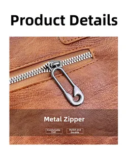 Detail of safety pin metal zipper pull on textured brown leather crossbody bag