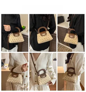 Polka dot mini trapezoid bag shown in various carrying styles with metal twist lock