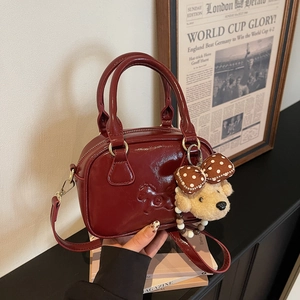 Mini burgundy leather bowling bag with horse embossing and a cute dog plush charm