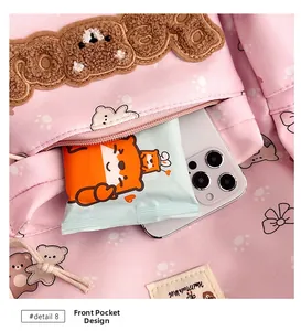 Detailed front pocket of pink cartoon backpack with plush bear embroidery and storage space