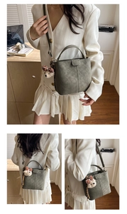 Detailed views of vintage suede bucket bag with adjustable strap and cute bear charm