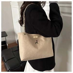 Détail du sac bandoulière en toile avec chaîne dorée et pendentif cerf