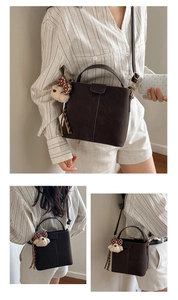 Detail of vintage brown suede bucket bag with adjustable strap and cute bear charm