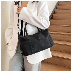 Dettaglio di una borsa tote vintage nera con trama opaca e cuciture decorative