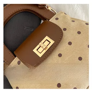 Detail of a vintage polka dot handbag featuring a gold metallic twist-lock closure