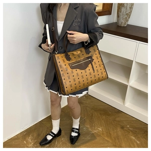 Detail of bear pattern tote bag with monogram texture and front zipper pocket