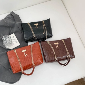 Three crocodile embossed leather tote bags with gold deer charms in black, brown and orange
