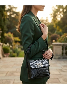 Detail of crossbody bag with zebra print flap and crocodile texture black leather