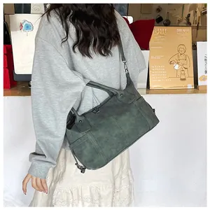 Dettaglio della borsa tote vintage con texture cerata, tasca laterale e tracolla regolabile