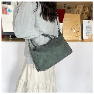 Dettaglio della borsa Boston vintage verde scuro in pelle PU opaca con tracolla