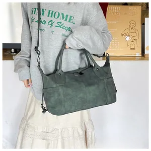 Dettaglio della borsa tote vintage verde scuro con texture opaca e tracolla regolabile