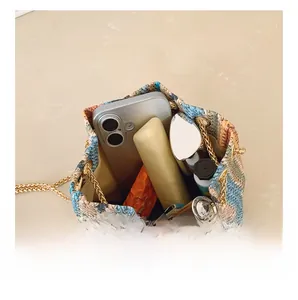 Close-up showing internal capacity of large colorful straw woven bucket bag with chain