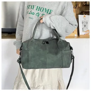 Dettaglio della borsa vintage verde opaco con tasca laterale e tracolla regolabile