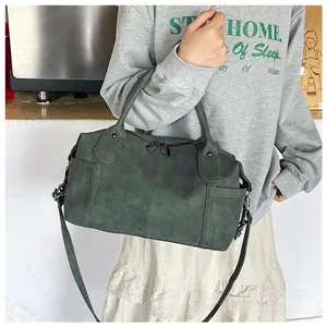 Dettaglio della borsa tote vintage verde scuro con doppi manici e tracolla regolabile