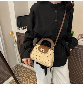 Chic beige polka dot trapezoid handbag with brown leather handle and gold twist lock