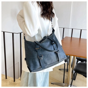 Detailed back view of a vintage dark grey PU leather tote bag worn as a shoulder bag