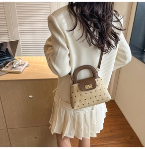 Detailed back view of model wearing a polka dot crossbody bag with golden metal clasp
