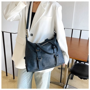 Deep blue large tote bag with textured faux leather and adjustable strap shown on model