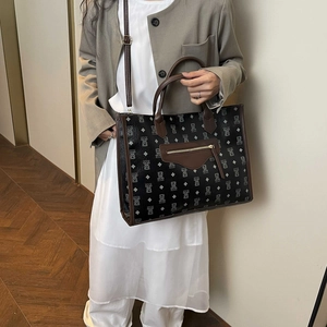Fashionable black cartoon bear tote bag with brown leather handles and adjustable strap