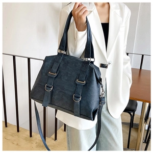 Detail of grey-blue large capacity tote bag with decorative straps and metal D-rings