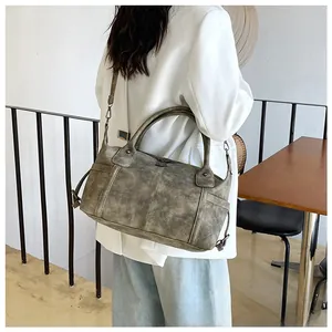 Dettaglio della borsa tote vintage con tasche laterali e finiture metalliche rustiche