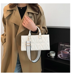 White quilted square bag with wide contrast strap styled with khaki trench coat