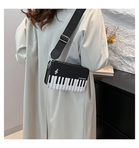 Detail of piano themed crossbody bag with keyboard pattern and I LOVE MUSIC text