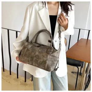 Dettaglio borsa tote vintage marrone con doppi manici e tasche laterali sulla modella