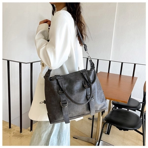 Detail of dark gray vintage tote bag with metal rings and adjustable shoulder strap