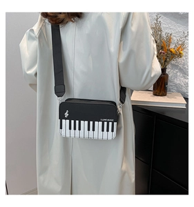 Detail of piano themed crossbody bag with I LOVE MUSIC print and keyboard pattern
