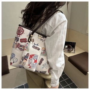 Detail view of large graffiti tote bag with Hong Kong city print and small charm bag