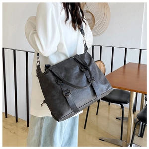 Detail of a large dark grey PU leather tote bag with vintage texture and metal rings