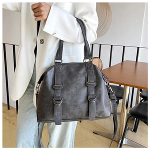 Detailed view of dark grey PU leather tote bag with silver buckle straps and top handles
