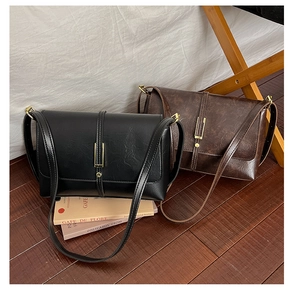 Detail of vintage flap crossbody bags in black and brown with vertical metal buckle design
