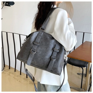 Detailed side view of a large vintage PU leather tote bag worn as a shoulder bag