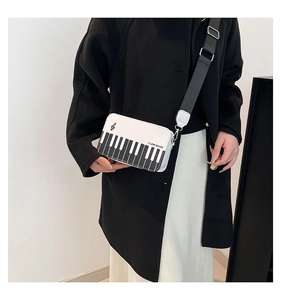 Detail of piano keyboard pattern bag with I LOVE MUSIC slogan and wide strap