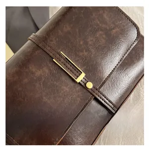 Gros plan du sac en cuir vintage marron avec texture marbrée et boucle en métal doré
