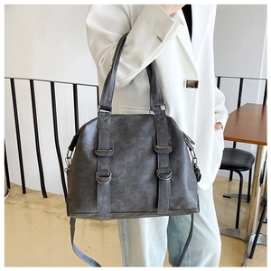 Macro detail of dark grey vintage tote bag showing weathered faux leather texture and D-rings