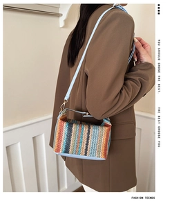 Détail d'un sac bandoulière tissé coloré avec bordure en cuir bleu clair et crochets