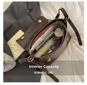 Capacité interne du sac bandoulière vintage marron foncé avec maquillage et téléphone