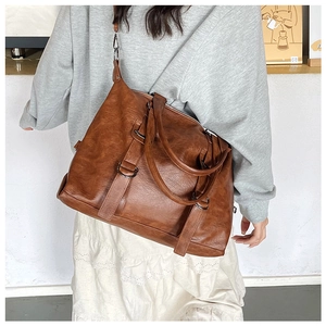 Detailed texture of brown vintage PU leather handbag with black metal buckle and straps
