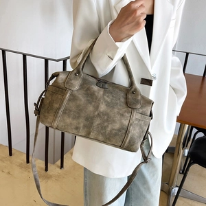 Borsa tote opaca grigio-verde retrò con tracolla regolabile mostrata in un look trendy