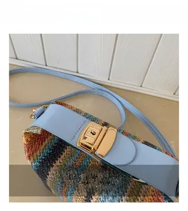 Gros plan du fermoir doré et du motif tissé coloré sur le sac bandoulière ethnique