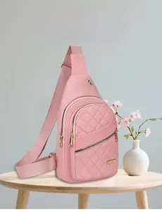 Detailed view of pink quilted crossbody bag with embroidery stitching and earphone port
