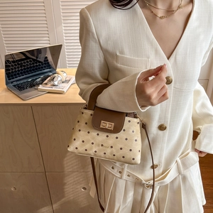Chic beige quilted shoulder bag with brown polka dots and leather flap shown with model