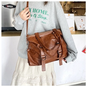 Close-up of vintage dark brown PU leather tote bag with soft texture and handles
