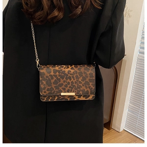 Detailaufnahme der Leoparden-Umhängetasche mit Goldkette auf schwarzem Blazer