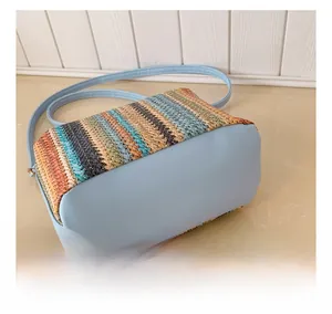 Détail de la texture en paille tressée rayée et de la base bleu clair du sac